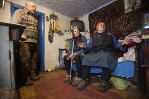 Kateryna Shklyar, right, speaks to The Associated Press as her husband, Dmytro, left, and Halyna Moroka gather near her at her house in the village of Nevelske in eastern Ukraine, on Friday, Dec. 10, 2021. With the bloody conflict between Russia-backed separatists and Ukrainian forces now more than seven years old, there are fears that a buildup of armed forces on Russia’s side of the border could lead to an invasion or the resumption of full-scale hostilities. “We don’t want war!” exclaimed Kateryna Shklyar, who shares the fear with her husband. (AP Photo/Andriy Dubchak)