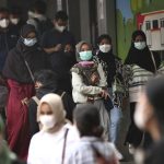 People wearing face masks as a precaution against the new coronavirus outbreak, walk through a train station in Jakarta, Indonesia, Thursday, Dec. 16, 2021. The Indonesian government on Thursday announced that the country has detected its first case of omicron variant on Wednesday evening. (AP Photo/Tatan Syuflana)