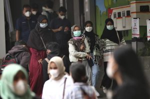 People wearing face masks as a precaution against the new coronavirus outbreak, walk through a train station in Jakarta, Indonesia, Thursday, Dec. 16, 2021. The Indonesian government on Thursday announced that the country has detected its first case of omicron variant on Wednesday evening. (AP Photo/Tatan Syuflana)