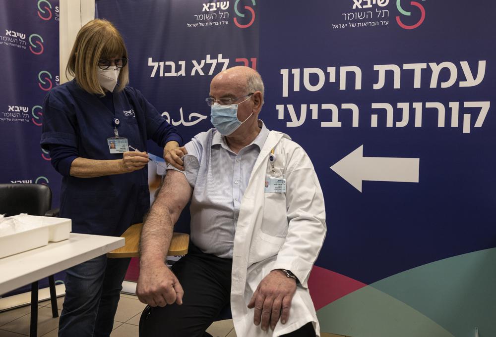 Professor Jacov Lavee receives a fourth dose of Pfizer-BioNTech COVID-19 vaccine, at Sheba Medical Center in Ramat Gan, Israel, Monday, Dec. 27, 2021. Israel began trials of a fourth dose of coronavirus vaccine on Monday with 150 medical personnel who received a booster dose in August in what is believed to be the first study of its kind. (AP Photo/Tsafrir Abayov)