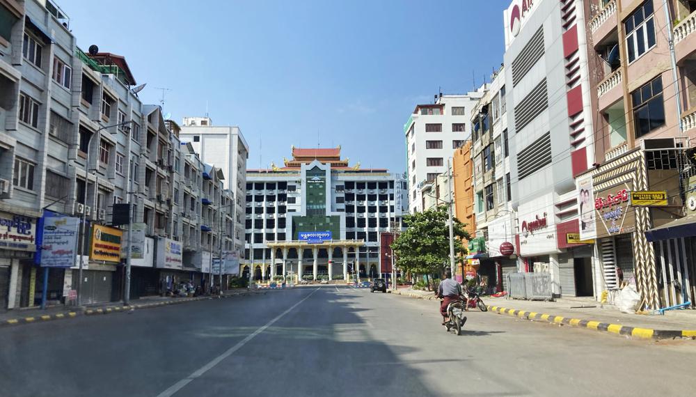A man rides a motorbike on an empty street near a railway station Friday, Dec. 10, 2021, in Mandalay, central Myanmar. Streets were seen empty in Mandalay Friday as people participated in a “silent strike” to mark International Human Rights Day. Many offices, shops and restaurants were closed and people stayed indoors in protest of the military takeover. (AP Photo)
