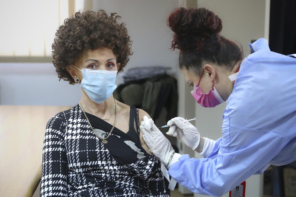 A woman is administered a COVID-19 vaccine at a center on the outskirts of Sarajevo, Bosnia, Sunday, Dec. 12, 2021. Some vaccine late-takers in Bosnia say they recently decided to finally embrace Covid-19 shots after numerous European countries started tightening their anti-virus rules, including by requiring proof of vaccination from foreign visitors before letting them in and giving them access to public venues within their borders. (AP Photo)