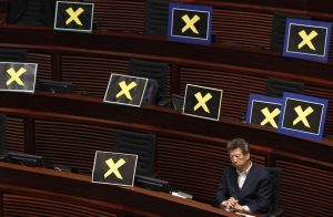 FILE – Pro-democracy lawmaker Ronny Tong sits with placards of yellow crosses placed after the lawmakers walk out of the legislative chamber to protest against Chief Secretary Carrie Lam who unveiled the Beijing-backed election reform package’s details, in Hong Kong on April 22, 2015. Elections for Hong Kong’s Legislative Council on Sunday, Dec. 19, 2021 mark the culmination of Beijing’s campaign to rein in the body that had once kept it from imposing its unrestrained will over the semi-autonomous territory. (AP Photo/Vincent Yu, File)