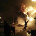 In this photo released by the Syrian official news agency SANA, firefighters work at the scene of missiles attack, at the seaport of the coastal city of Latakia, Syria, Tuesday, Dec. 28, 2021. Israeli missiles fired from the Mediterranean struck the Syrian port of Latakia early Tuesday, igniting a fire in the container terminal, Syrian state media reported, in the second such attack on the vital facility this month. (SANA via AP)