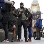 People queue on Westminster Bridge for booster jabs at St Thomas’ Hospital, London, Monday, Dec. 13, 2021. Britain faces a “tidal wave” of infections from the omicron coronavirus variant and British Prime Minister Boris Johnson has announced a huge increase in booster vaccinations to strengthen defenses against it. (Kirsty O’Connor/PA via AP)