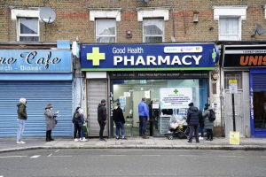 People wait in line to receive a ‘Jingle Jab’ Covid vaccination booster injection at the Good Health Pharmacy, north London, Saturday, Dec. 25, 2021. Thousands of people across England are spending a few minutes of Christmas Day to line up under leaden winter skies to be vaccinated against COVID-19 as the omicron variant fuels a surge in infections across the country. The Good Health Pharmacy in north London is one of dozens of vaccination sites that kept their doors open Saturday to administer “jingle jabs” amid a government push to offer booster shots to all adults by the end of the year. (Gareth Fuller/PA via AP)