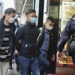 Editor of “Stand News” Patrick Lam, second from left, is arrested by police officers in Hong Kong, Wednesday, Dec. 29, 2021. Hong Kong police say they have arrested seveal current and former staff members of the online media company for conspiracy to publish a seditious publication. (AP Photo/Vincent Yu)
