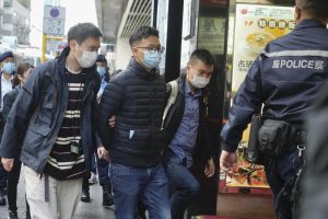 Editor of “Stand News” Patrick Lam, second from left, is arrested by police officers in Hong Kong, Wednesday, Dec. 29, 2021. Hong Kong police say they have arrested seveal current and former staff members of the online media company for conspiracy to publish a seditious publication. (AP Photo/Vincent Yu)