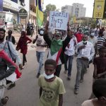 People march during a protest to denounce the October military coup, in Khartoum, Sudan, Saturday, Dec. 25, 2021. Sudanese security forces fired tear gas to disperse protesters as thousands rallied since earlier in the day, even as authorities tightened security across Khartoum, deploying troops and closing all bridges over the Nile River linking the capital with its twin city of Omdurman and the district of Bahri, the state-run SUNA news agency reported.(AP Photo/Marwan Ali)