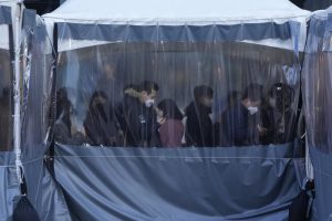 FILE – People queue in line to wait for the coronavirus testing at a makeshift testing site in Seoul, South Korea on Dec. 22, 2021. Caseloads of omicron have remained relatively low in many countries in Asia. For now, many remain insulated from the worst, although the next few months will remain critical. (AP Photo/Ahn Young-joon, File)
