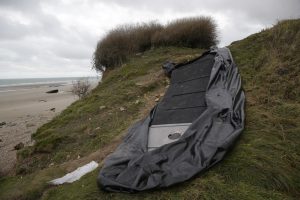FILE – A damaged inflatable small boat is pictured on the shore in Wimereux, northern France, Thursday, Nov. 25, 2021 in Calais, northern France. The Paris prosecutor’s office said it has received a manslaughter lawsuit for failure to help in the tragic capsizing last month of a boat in the English Channel that cost the lives of at least 27 people trying to reach Britain. The manslaughter lawsuit, filed Friday, Dec. 17, 2021 by the French humanitarian organization Utopia 56, accuses the maritime prefect of the Channel and North Sea, the Regional Operational Centre for Surveillance and Rescue of Gris-Nez in the Pas-de-Calais and the British Coast Guard of not doing enough to prevent the deaths. (AP Photo/Michel Spingler, File)