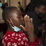 A churchgoer wears a face mask to curb the spread of the coronavirus as she attends a Mass at Holy Family Cathedral in Nairobi, Kenya, Saturday, Dec. 25, 2021. (AP Photo/Sayyid Abdul Azim)