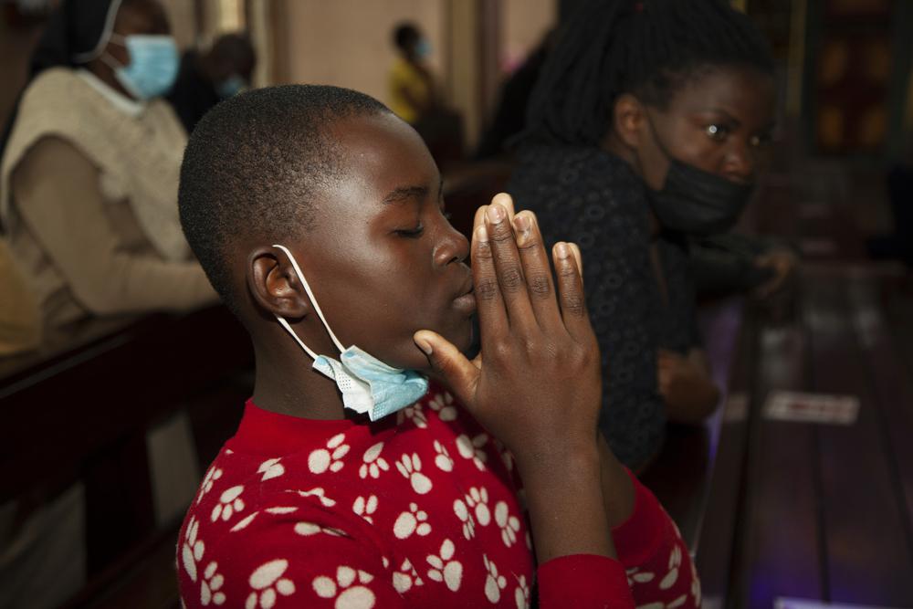 A churchgoer wears a face mask to curb the spread of the coronavirus as she attends a Mass at Holy Family Cathedral in Nairobi, Kenya, Saturday, Dec. 25, 2021. (AP Photo/Sayyid Abdul Azim)