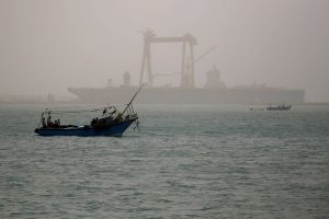 A boat is seen on a dusty weather in Suez near the Suez Canal