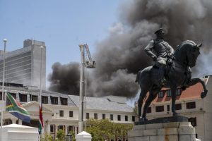 Firemen spray water on flames erupting from a building at South Africa’s Parliament in Cape Town Sunday Jan. 2, 2022. (AP Photo/Jerome Delay)