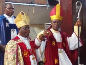 Prelate of the Methodist Church Nigeria, His Eminence, Dr Samuel Chukwuemeka Kanu Uche (right) lifting the hand of the new 7th Arch Bishop of the Calabar Archdiocese, Most Rev Chimezuo ON Nwankpa