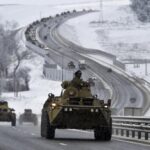FILE – A convoy of Russian armored vehicles moves along a highway in Crimea, Tuesday, Jan. 18, 2022. With tens of thousands of Russian troops positioned near Ukraine, the Kremlin has kept the U.S. and its allies guessing about its next moves in the worst Russia-West security crisis since the Cold War. (AP Photo, File)