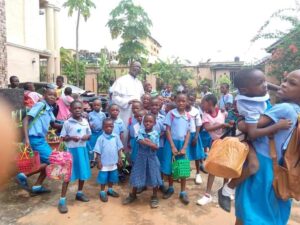 Rev. Fr. Augustine Oburota calming down some of the traumatised kids at Awada school
