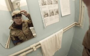 Yuliia Paievska, known as Taira, looks in a mirror and turns off her camera in Mariupol, Ukraine, on Feb. 27, 2022. The celebrated Ukrainian medic, who used the body camera to record her work in Mariupol while the port city was under Russian siege, was later captured by Russian troops. Ukrainian President Volodymyr Zelenskyy announced Friday, June 17, 2022, that Russia has freed Paievska. (Yuliia Paievska via AP)