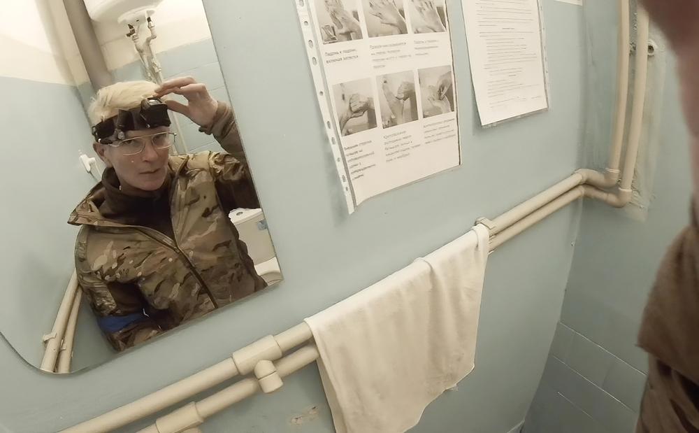 Yuliia Paievska, known as Taira, looks in a mirror and turns off her camera in Mariupol, Ukraine, on Feb. 27, 2022. The celebrated Ukrainian medic, who used the body camera to record her work in Mariupol while the port city was under Russian siege, was later captured by Russian troops. Ukrainian President Volodymyr Zelenskyy announced Friday, June 17, 2022, that Russia has freed Paievska. (Yuliia Paievska via AP)