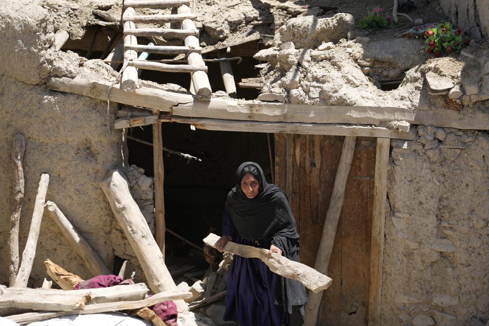 Afghan woman cleans up after an earthquake in Gayan village, in Paktika province, Afghanistan, Friday June 24, 2022. A powerful earthquake struck a rugged, mountainous region of eastern Afghanistan early Wednesday, flattening stone and mud-brick homes in the country’s deadliest quake in two decades, the state-run news agency reported. (AP Photo/Ebrahim Nooroozi)