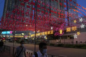 Light installations with Chinese and Hong Kong flags are displayed to celebrate the 25th anniversary of Hong Kong handover to China, in Hong Kong, Thursday, June 23, 2022. As the former British colony marks the 25th anniversary of its return to China, reeling from pandemic curbs that devastated business and a crackdown on its pro-democracy movement, Hong Kong leaders say it is time to transform again and become a tech center that relies more on ties with nearby Chinese factory cities than on global trade. (AP Photo/Kin Cheung)