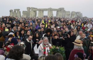 Arthur Uther Pendragon, center, joins people as they gather at the Heel Stone during sunrise for the Summer Solstice festivities at Stonehenge in Wiltshire, England, Tuesday, June 21, 2022. After two years of closure due to the COVID-19 pandemic, Stonehenge reopened Monday for the Summer Solstice celebrations. (Andrew Matthews/PA via AP)