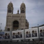 Campaign posters hang in front of the Cathedral of Saint Mary Major in Marseille, southern France, Thursday, June 16, 2022. President Emmanuel Macron urged the French to give him a “strong majority” Sunday in the second, decisive round of nationwide parliamentary elections. (AP Photo/Daniel Cole)