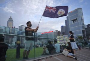 FILE – A protester waves Hong Kong British colony flag during continuing pro-democracy rallies in Tamar Park, Hong Kong, on Sept. 3, 2019. When the British handed its colony Hong Kong to Beijing in 1997, it was promised 50 years of self-government and freedoms of assembly, speech and press that are not allowed Chinese on the Communist-ruled mainland. As the city of 7.4 million people marks 25 years under Beijing’s rule on Friday, those promises are wearing thin. Hong Kong’s honeymoon period, when it carried on much as it always had, has passed, and its future remains uncertain, determined by forces beyond its control. (AP Photo/Vincent Yu, File)