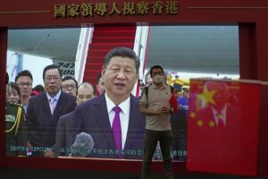 A visitor poses for a photograph in front of a TV showing Chinese president Xi Jinping at an exhibition to mark the 25th anniversary of the former British colony’s return to Chinese rule, in Hong Kong, Friday, June 24, 2022. Hong Kong authorities, citing “security reasons,” have barred more than 10 journalists from covering events and ceremonies this week marking the 25th anniversary of Hong Kong’s return to China, according to the Hong Kong Journalists Association. (AP Photo/Kin Cheung)
