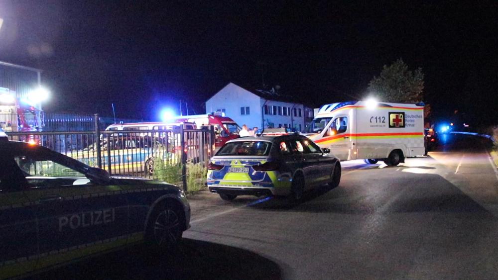 In this video still imgage police and emergency services stand at an asylum seeker shelter after a knife attack in Kressbronn, Germany, Sunday, June 26, 2022. A knife-wielding attacker has stabbed several people in a shelter for asylum-seekers in southern Germany, killing one man and wounding at least five people. (Davor Knappmeyer/dpa via AP)