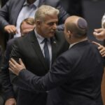 Israeli Prime Minister Naftali Bennett, right, and Foreign Minister Yair Lapid after a the vote on a bill to dissolve the parliament, at the Knesset, Israel’s parliament, in Jerusalem, Thursday, June 30, 2022. Israel’s parliament has voted to dissolve itself, sending the country to the polls for the fifth time in less than four years. (AP Photo/Ariel Schalit)