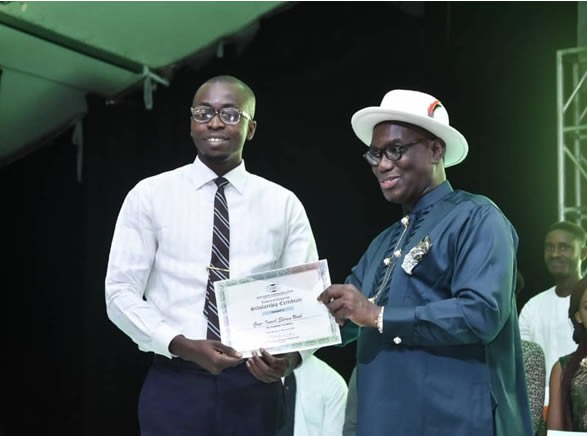 Adegbulugbe (R) presenting a scholarship award to a recepient from Ikuru town