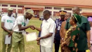 Acting Governor Philip Shaibu presenting a certificate to Best Corp Member in Edo