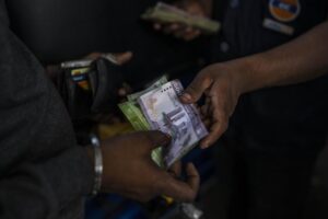 A man pays in Sri Lankan Rupees after buying petrol at a fuel station in Colombo, Sri Lanka, July 17, 2022. Bankruptcy has forced the island nation’s government to a near standstill. Parliament is expected to elect a new leader Wednesday, paving the way for a fresh government, but it is unclear if that’s enough to fix a shattered economy and placate a furious nation of 22 million that has grown disillusioned with politicians of all stripes. (AP Photo/Rafiq Maqbool)