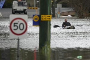 A man paddles his kayak through a flooded street at Windsor on the outskirts of Sydney, Australia, Tuesday, July 5, 2022. Hundreds of homes have been inundated in and around Australia’s largest city in a flood emergency that was impacting 50,000 people, officials said Tuesday. (AP Photo/Mark Baker)