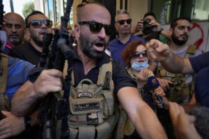 Lebanese State Security forces surround Lebanese Judge Ghada Aoun, wearing face mask, as she leaves the entrance of Central Bank following a raid to pursue Central Bank Governor Riad Salameh, who she has charged for corruption in Beirut, Lebanon, Tuesday, July 19, 2022. (AP Photo/Bilal Hussein)