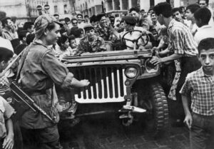 FILE – A jeep of the Algerian Liberation Front (FLN) is surrounded by an enthusiastic crowd in Algiers, Algeria, in July 1962. Algeria is celebrating 60 years of independence from France on Tuesday July 5, 2022 with nationwide ceremonies, a pardon of 14,000 prisoners and its first military parade in years. Tuesday’s events mark 60 years since the official declaration of independence on July 5, 1962, after a brutal seven-year war which ended 132 years of colonial rule. The war, which killed at least 1.5 million people, remains a point of tension in relations between Algeria and France. (AP Photo, File)