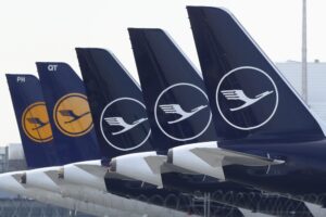 FILE –German Lufthansa planes sit parked in a line at the airport in Munich, Germany, Thursday, March 26, 2020. Lufthansa says it will have to cancel almost all flights at its main Frankfurt and Munich hubs on Wednesday because of a strike by its German ground staff. (AP Photo/Matthias Schrader),file)