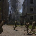 FILE – Ukrainian soldiers run after a missile strike hit a residential area, in Kramatorsk, Donetsk region, eastern Ukraine, Thursday, July 7, 2022. Injured residents sat dazed and covered in blood. A crater was now the centre of the courtyard. Last week, the governor of the Donetsk oblast Pavlo Kyrylenko urged the province’s more than 350,000 remaining residents to flee to safer towns further West, saying that evacuating the region was necessary to save lives and allow the Ukrainian army to better defend towns against a Russian advance. Many refuse to leave the city. (AP Photo/Nariman El-Mofty, File)