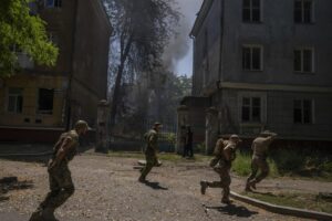 FILE – Ukrainian soldiers run after a missile strike hit a residential area, in Kramatorsk, Donetsk region, eastern Ukraine, Thursday, July 7, 2022. Injured residents sat dazed and covered in blood. A crater was now the centre of the courtyard. Last week, the governor of the Donetsk oblast Pavlo Kyrylenko urged the province’s more than 350,000 remaining residents to flee to safer towns further West, saying that evacuating the region was necessary to save lives and allow the Ukrainian army to better defend towns against a Russian advance. Many refuse to leave the city. (AP Photo/Nariman El-Mofty, File)