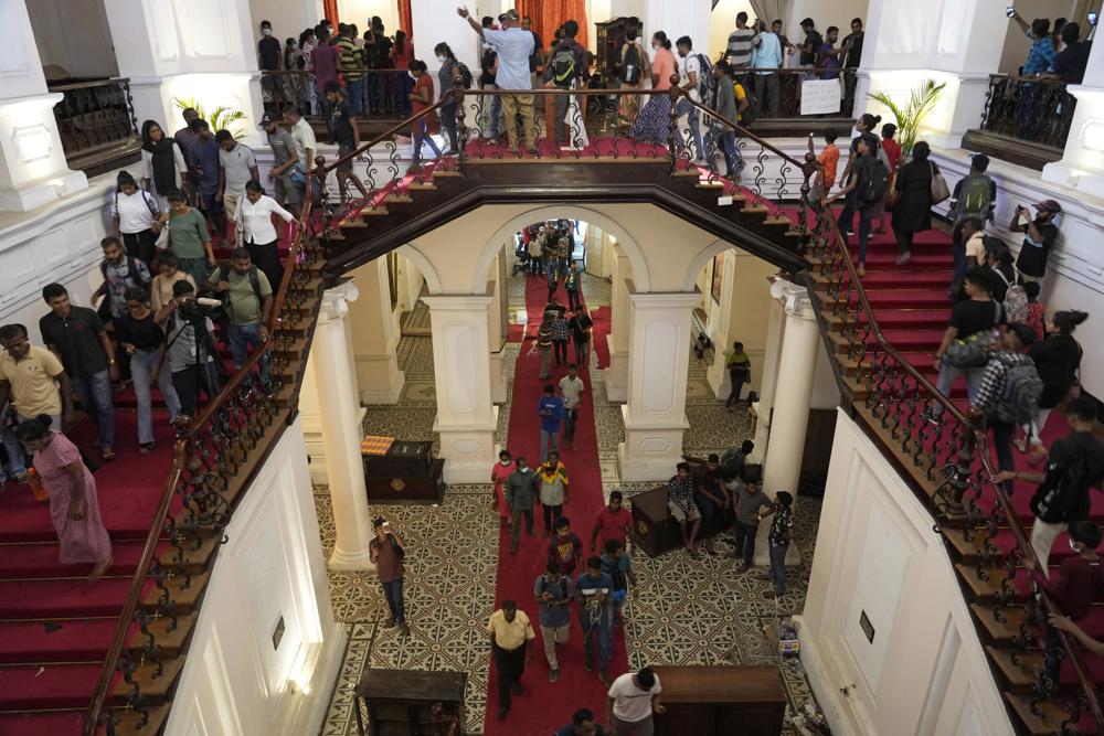 People arrives at the official residence of president Gotabaya Rajapaksa fourth days after it was stormed by anti government protesters in Colombo in Colombo, Sri Lanka, Wednesday, July 13, 2022. The president of Sri Lanka fled the country early Wednesday, days after protesters stormed his home and office and the official residence of his prime minister amid a monthslong economic crisis that triggered severe shortages of food and fuel.(AP Photo/Rafiq Maqbool)