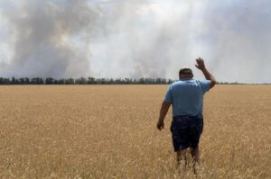 FILE – A farmer reacts as he looks at his burning field caused by the fighting at the front line in the Dnipropetrovsk region, Ukraine, Monday, July 4, 2022. Military officials from Russia and Ukraine are set to hold a meeting in Istanbul to discuss a United Nations plan to export blocked Ukrainian grain to world markets through the Black Sea. Russia’s invasion and war disrupted production and halted shipments of Ukraine, one of the world’s largest exporters of wheat, corn and sunflower oil. (AP Photo/Efrem Lukatsky)