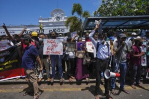 Trade Union activists and civil society members shout slogans against Acting President and Prime Minister Ranil Wickremesinghe as lawmakers prepare to elect a new president in Colombo, Sri Lanka, Tuesday, July 19, 2022. The protestors demanded Wickremesinghe be ousted and prevented from being elected as the successor to Gotabaya Rajapaksa who fled the country last week. (AP Photo/Eranga Jayawardena)