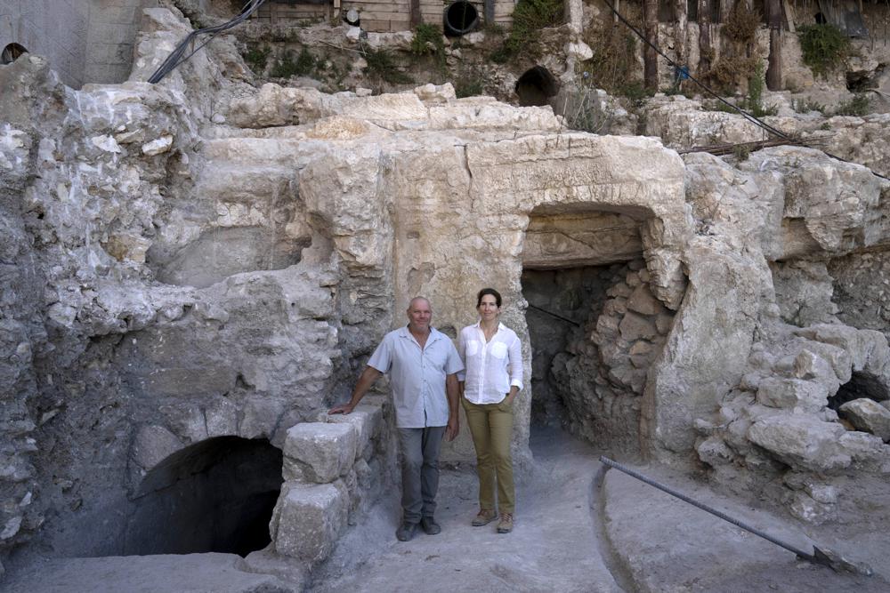 Hebrew University archaeologists Dr. Oren Gutfeld, left, and Michal Haber, pose for a portrait at the site of a Jewish ritual bath or mikveh, discovered near the Western Wall in the Old City of Jerusalem, Sunday, July 17, 2022. An excavation to build an accessible elevator from the Jewish Quarter to the Western Wall near the Temple Mount by the Hebrew University of Jerusalem’s Institute of Archaeology has unearthed the mikveh that dates back to the 1st Century CE. (AP Photo/Maya Alleruzzo)