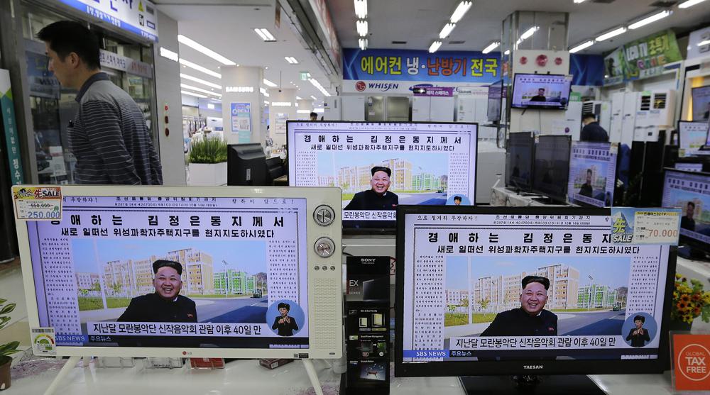 FILE – A man walks past TV monitors displaying a news program at an electronic shop in Seoul, South Korea, on Oct. 14, 2014, showing a North Korean newspaper with a photo of North Korean leader Kim Jong Un smiling, reportedly during his first public appearance in five weeks in Pyongyang, North Korea. The writing reads, “Honorable Kim Jong Un.” South Korea plans to lift its decades-long ban on public access to North Korean television, newspapers and other media as part of its efforts to promote mutual understanding between the rivals, officials said Friday, July 22, 2022, despite animosities over the North’s recent missile tests. (AP Photo/Ahn Young-joon, File)