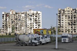 Cement trucks parked at a construction site of an apartment building under construction for residents of Mariupol affected by hostilities, in Mariupol, in territory under the government of the Donetsk People’s Republic, eastern Ukraine, Friday, July 1, 2022. (AP Photo)