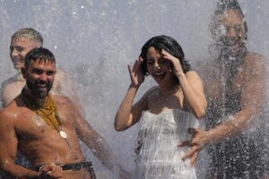 ADDS TROUPE’S NAME – Members of the Australian cabaret & circus troupe Briefs cool down in a fountain on the Southbank in London, Tuesday, July 19, 2022. Britain shattered its record for highest temperature ever registered Tuesday, with a provisional reading of 39.1 degrees Celsius (102.4 degrees Fahrenheit), according to the country’s weather office — and the heat was only expected to rise. (AP Photo/Frank Augstein)