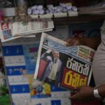 A man holds a newspaper with news of Ranil Wickremesinghe’s election in Colombo, Sri Lanka, Thursday, July 21, 2022. Sri Lanka’s prime minister was elected president Wednesday by lawmakers who opted for a seasoned, veteran leader to lead the country out of economic collapse, despite widespread public opposition. (AP Photo/Rafiq Maqbool)
