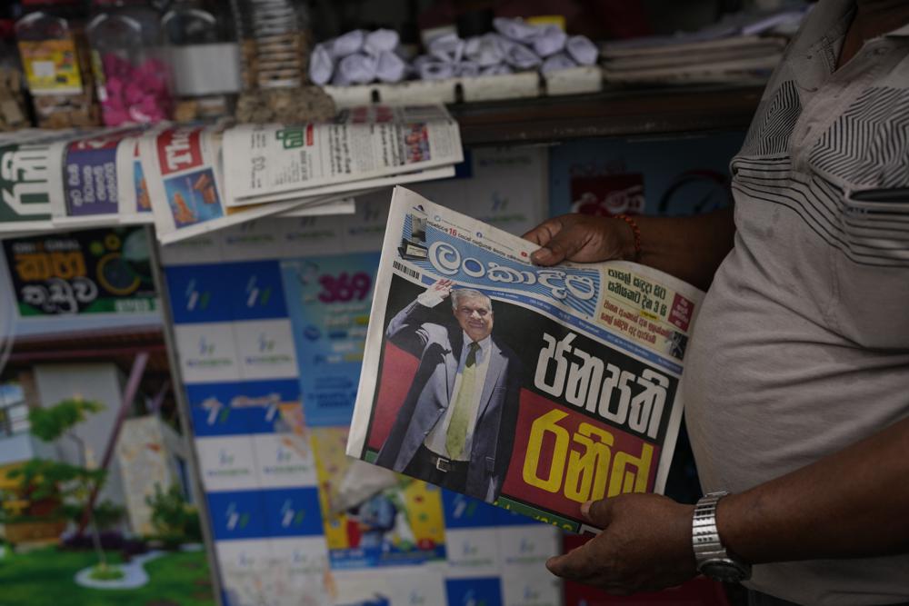A man holds a newspaper with news of Ranil Wickremesinghe’s election in Colombo, Sri Lanka, Thursday, July 21, 2022. Sri Lanka’s prime minister was elected president Wednesday by lawmakers who opted for a seasoned, veteran leader to lead the country out of economic collapse, despite widespread public opposition. (AP Photo/Rafiq Maqbool)
